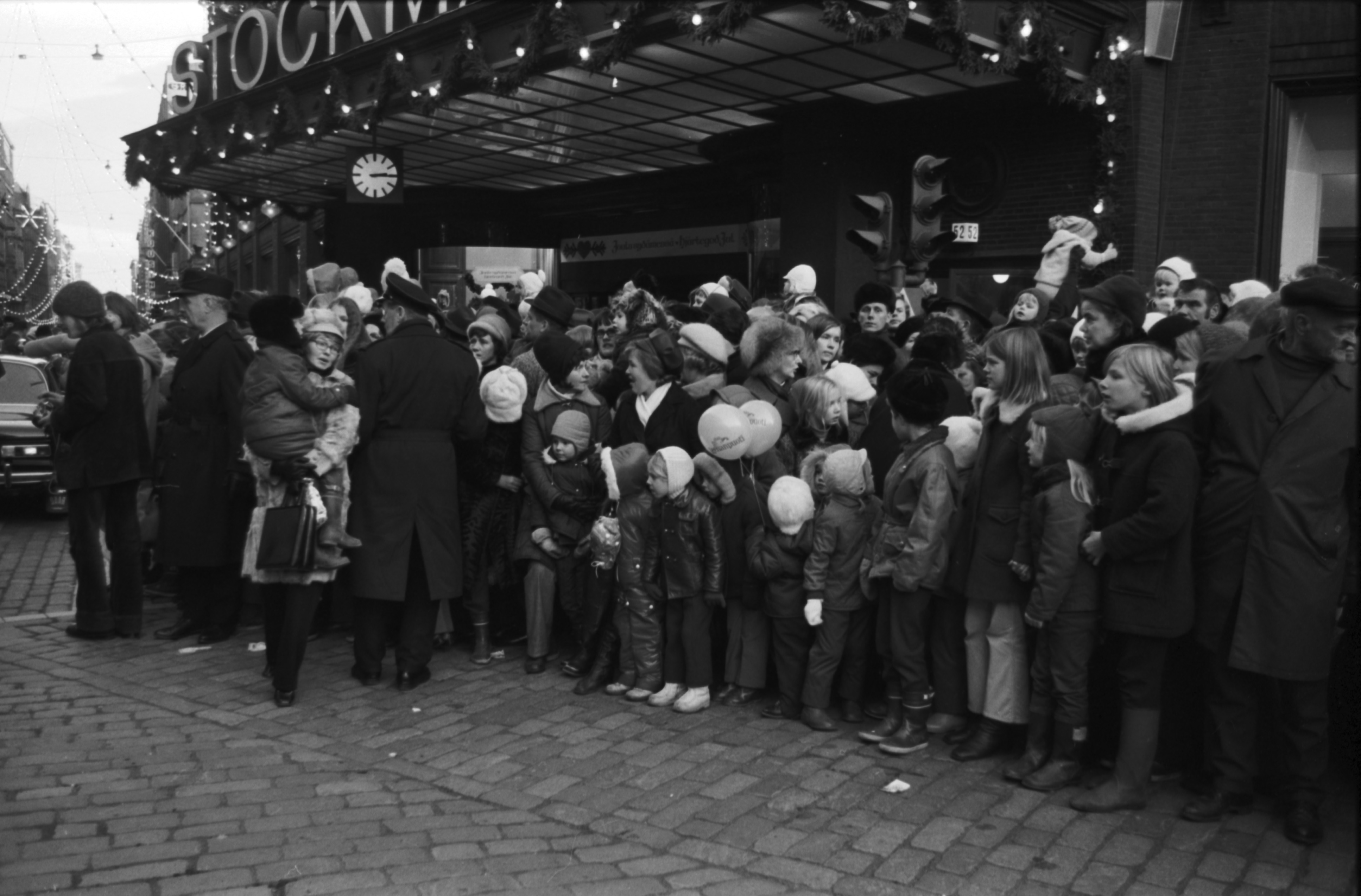 Aleksanterinkatu 52. Runsaslukuinen yleisö seuraamassa joulukadun avajaisparaatia Stockmannin tavaratalon sisäänkäynnin edustalla.