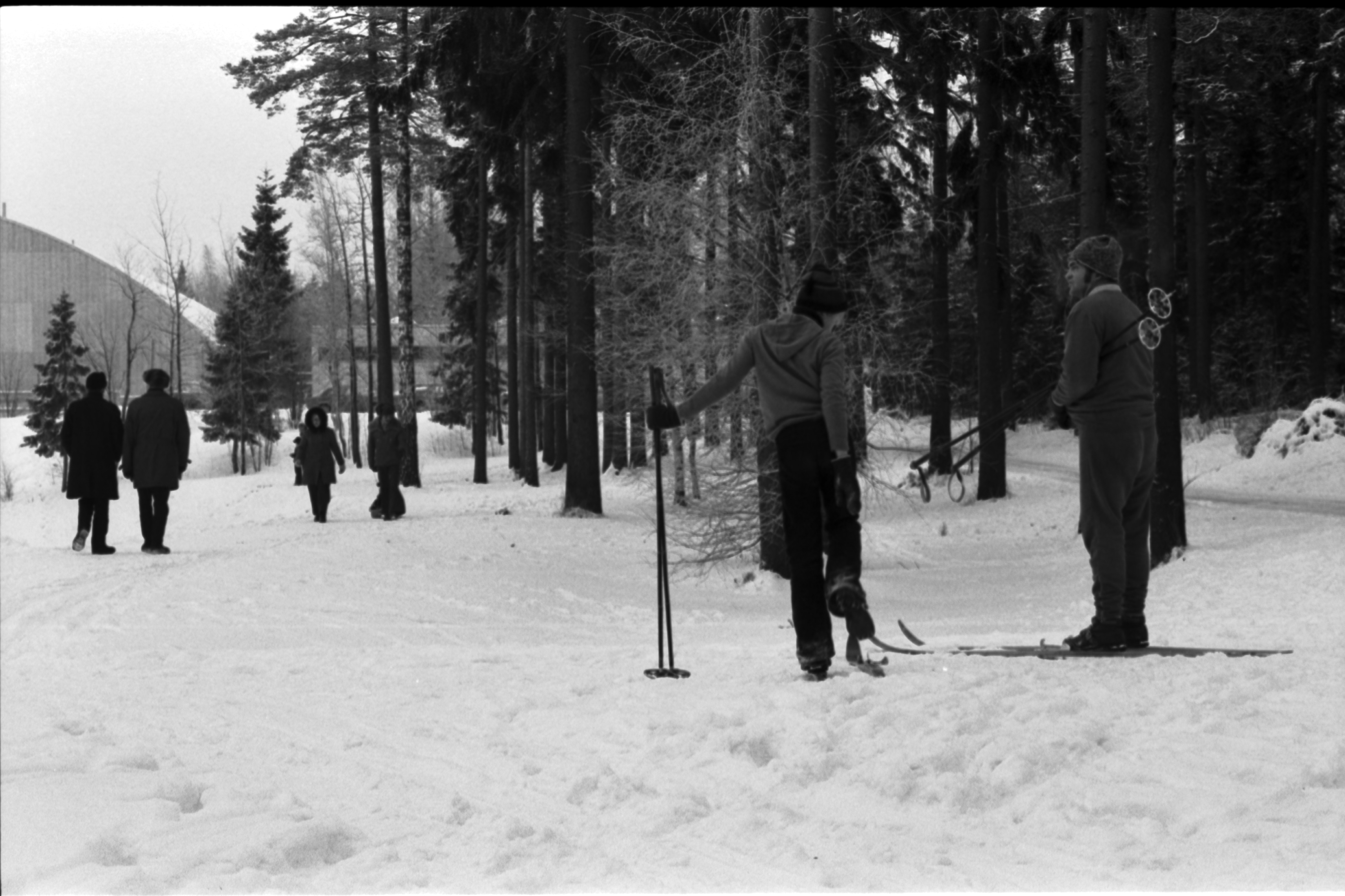 Pirkkolan urheilupuisto. Ihmisiä lähdössä hiihtolenkille Pirkkolan urheilupuistossa. Vasemmalla kaarevakattoinen sisäurheiluhalli.