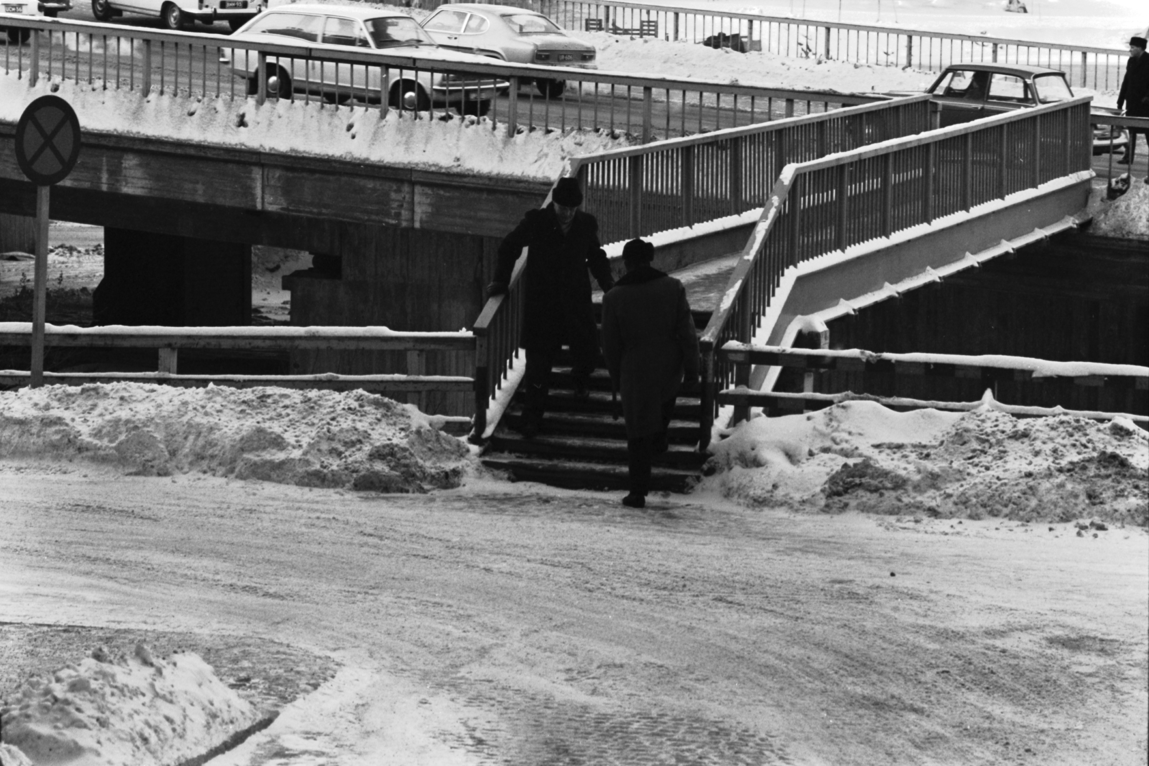 Kaksi miestä Kirjatyöntekijänkadulta Hakaniemen sillalle johtavan kävelysillan portaissa.