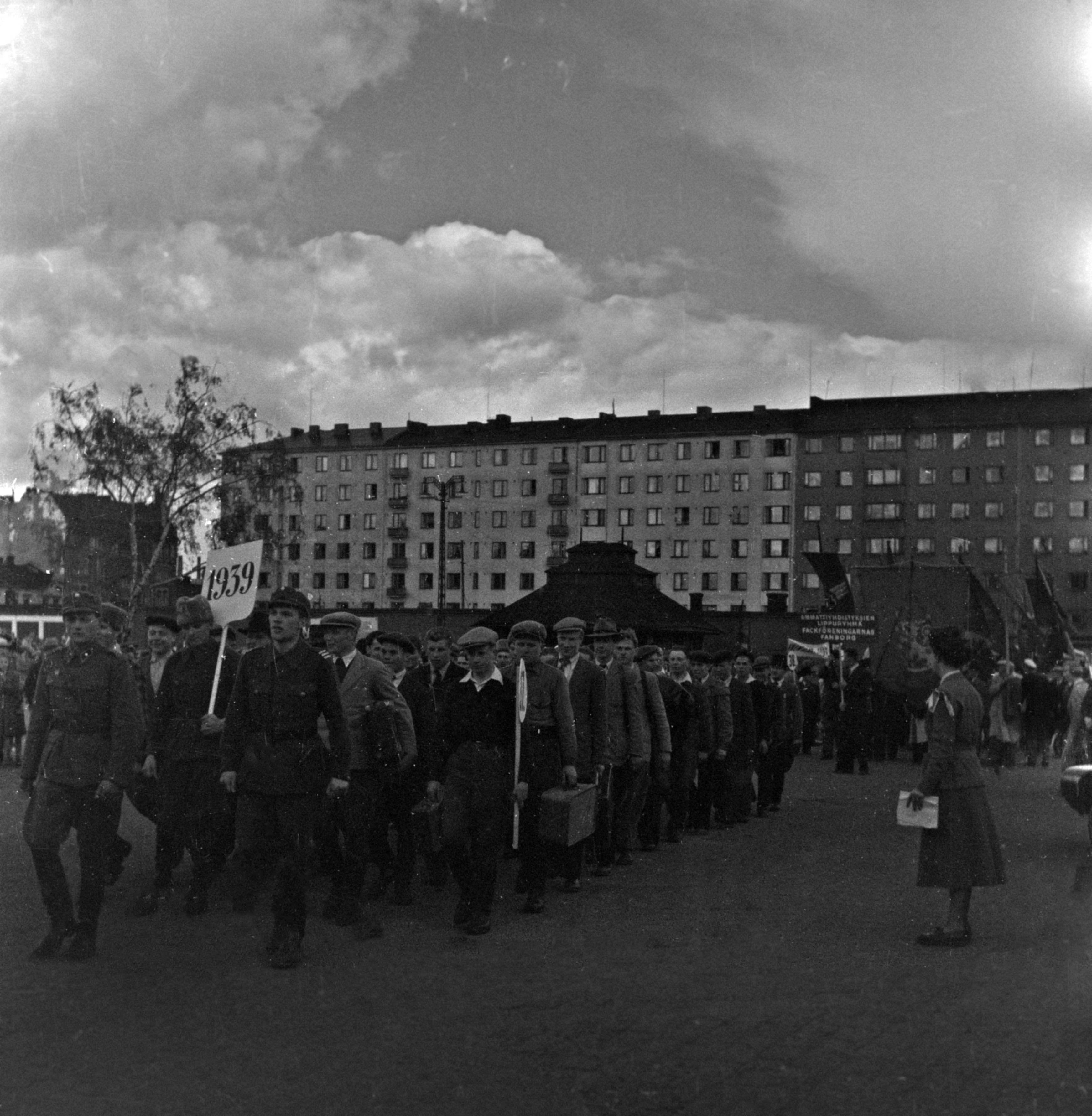 Hakaniementori. Helsingin 400-vuotisjuhlat. Helsingin historiaa esittelevä juhlakulkue. Vuosi 1939, lähtö talvisotaan. Taempana ammattiyhdistyksien lippuryhmä. Taustalla Viherniemenkatu 9-3.