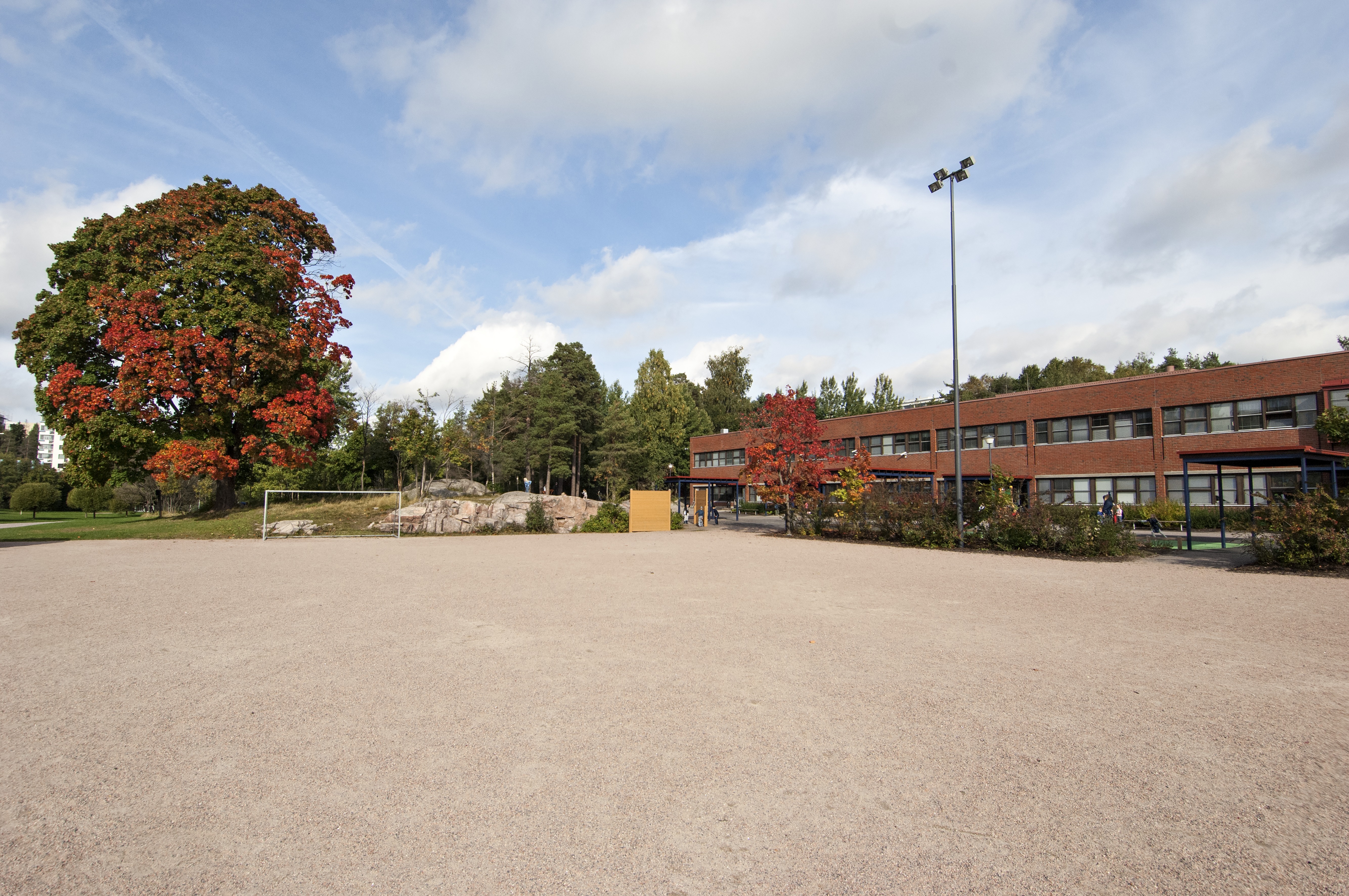 Pihlajiston ala-asteen koulurakennus. Koulun sisäänkäyntien puoleinen piha ja urheilukenttä.