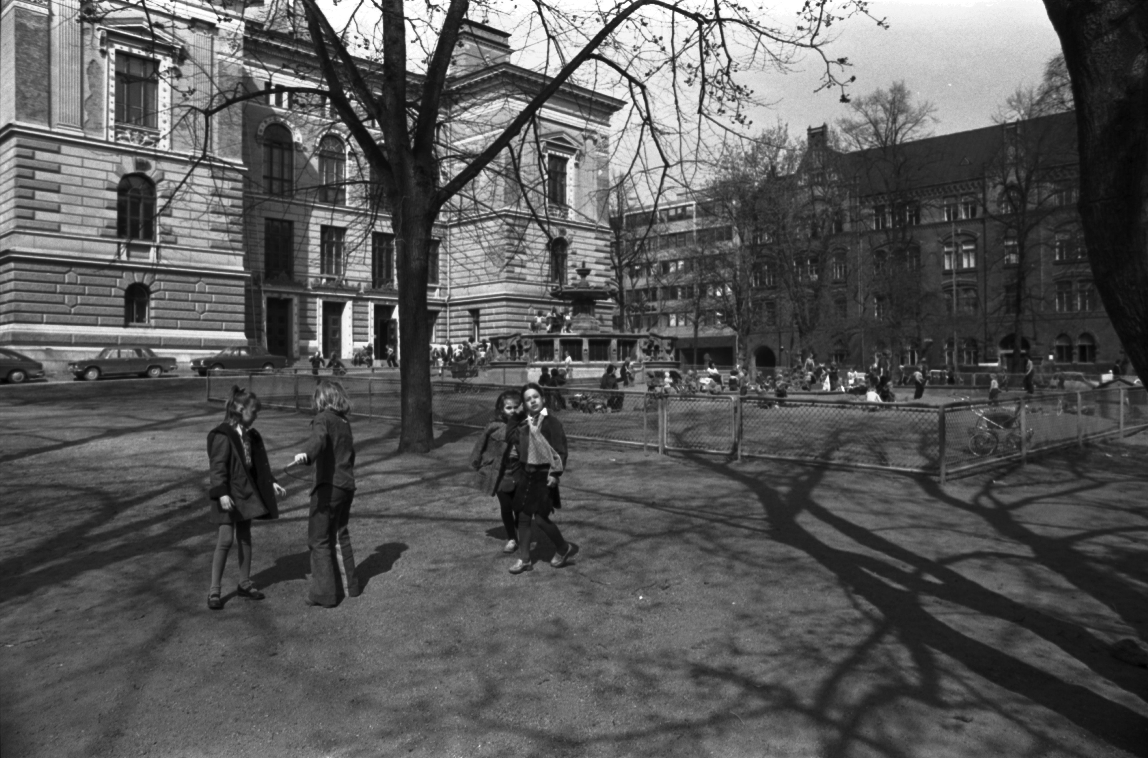 Säätytalon puisto. Lapsia keväisen Säätytalon puiston laidalla. Taustalla Säätytalo. Näkymä Kirkkokadun ja Ritarikadun kulmalta.