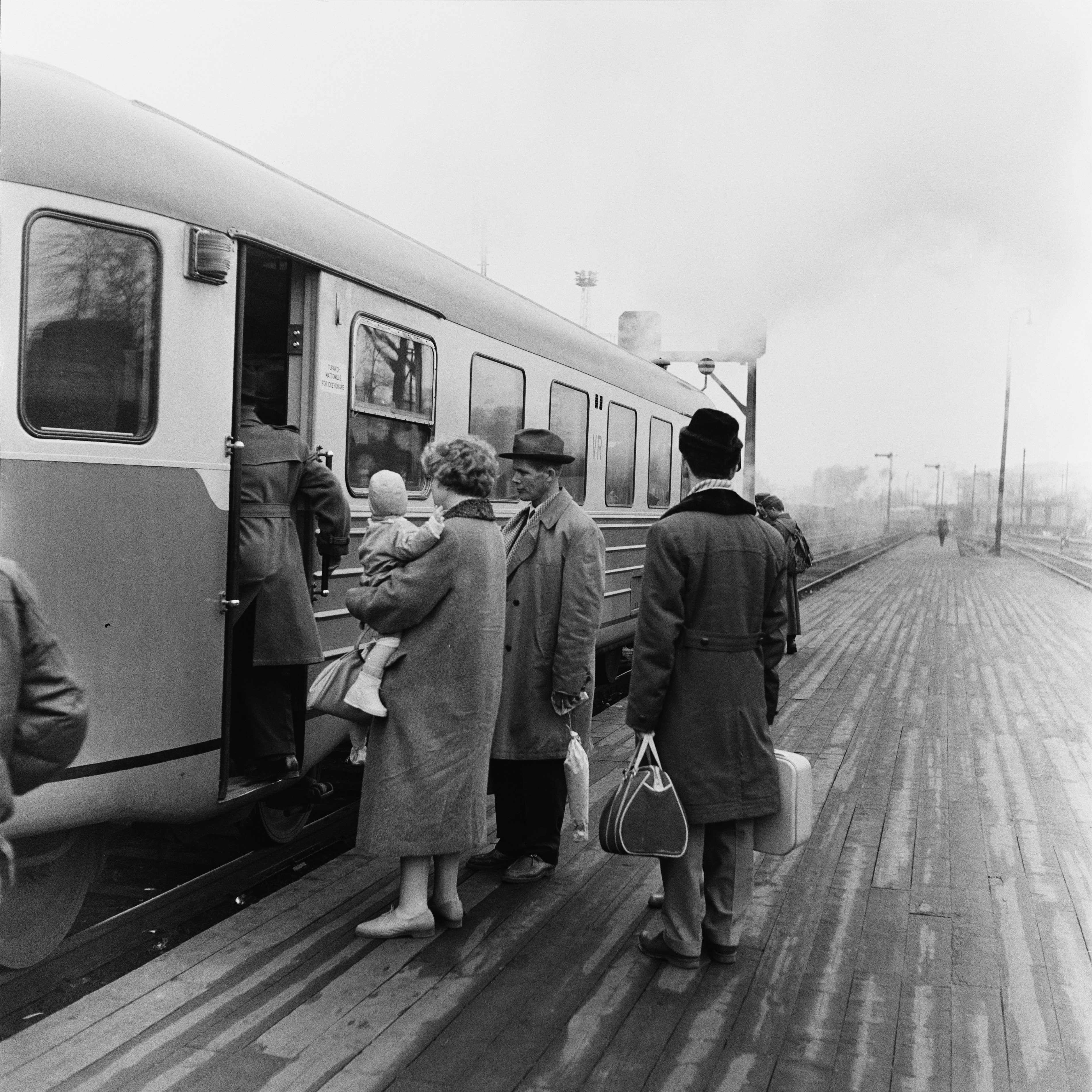 Matkustajia nousemassa kiskobussiin eli lättähattuun Rautatieasemalla.