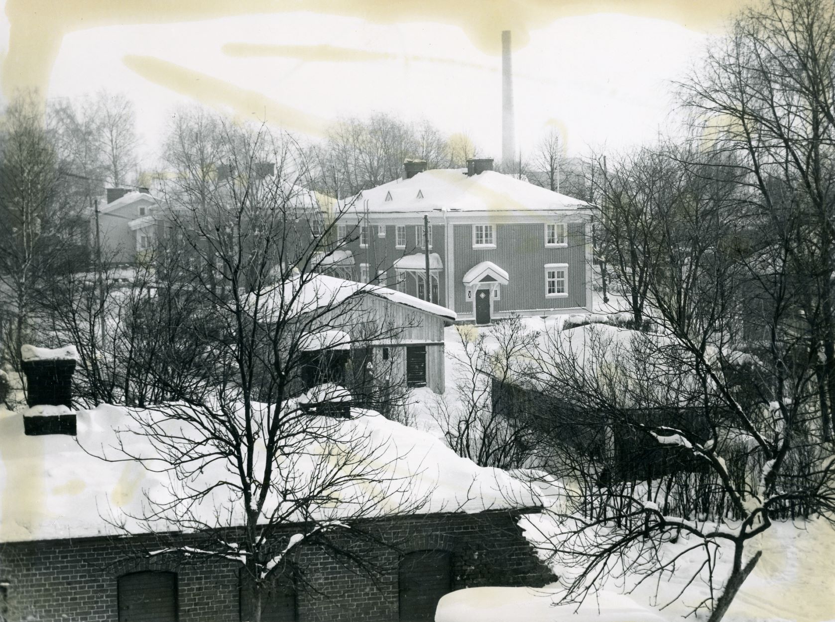 VR:n tiilivarasto ja sen takana kaksikerroksisia asuinkasarmeja (rakennettu 1924) kuvattuna Kirkkopolulta. Kuva: Riihimäen kaupunginmuseo