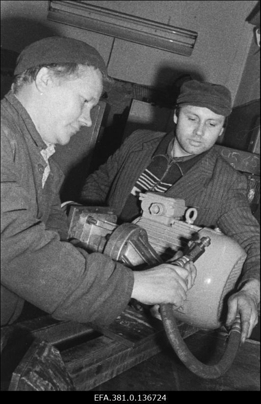 Narva Autobussi- ja Taksopargi gaasi elektrikeevitaja A. Iljin ja brigadir M. Kulakov monteerivad mootorit.