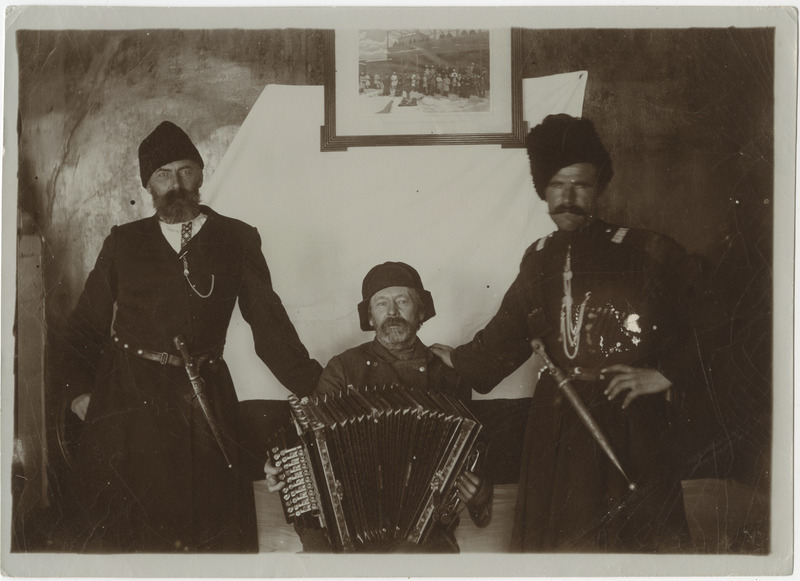 Kolm meest, keskmisel käes akordion