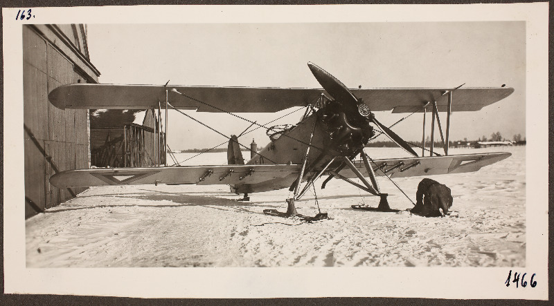 Vaade [Eesti Lennuväe] lennukile lumisel väljal angaaride taustal; foto 1. Lennuväedivisjoni fotopositiivide kogust