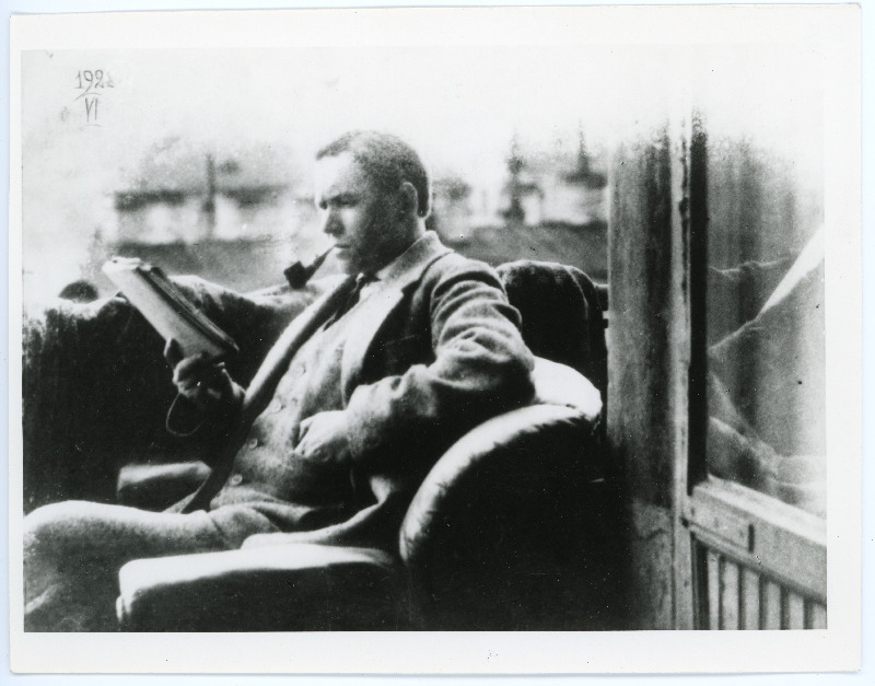 Albert Tiimann tugitoolis istumas ja lugemas, piip suus