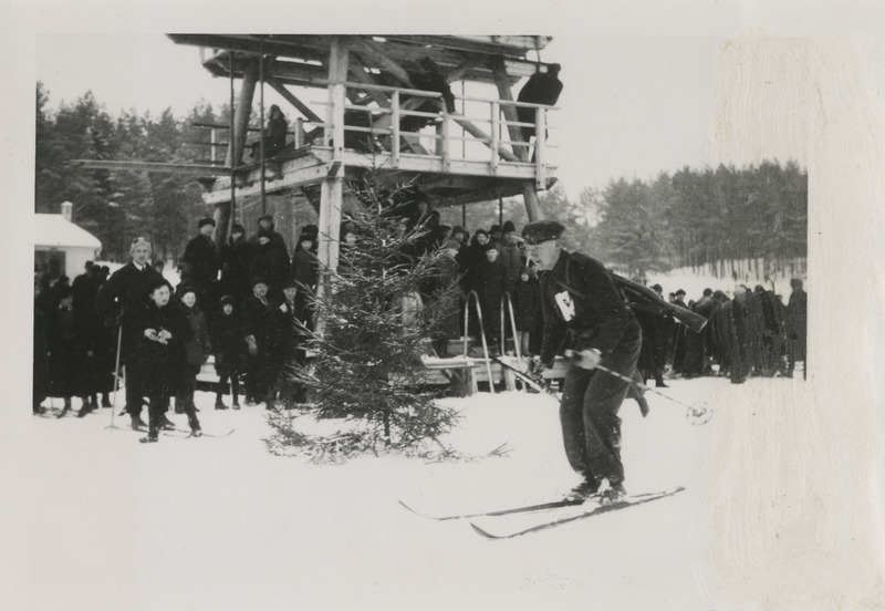 Kaitseliidu Tartumaa maleva suusapäev Elvas 21.02.1937, 18 km patrullsuusatamise võitja Arkadi Võlli saabumas finišisse. Taustal tribüünina kasutust leidev Elva ujumisbasseini hüppetorn