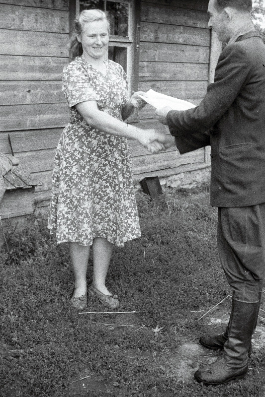 ELKNÜ Kingissepa Rajoonikomitee sekretär Evald Alt ELKNÜ Keskkomitee aukirja üle andmas Kingissepa rajooni parimale lüpsjale Vätta Kaluri kolhoosist Maimu Sepale.