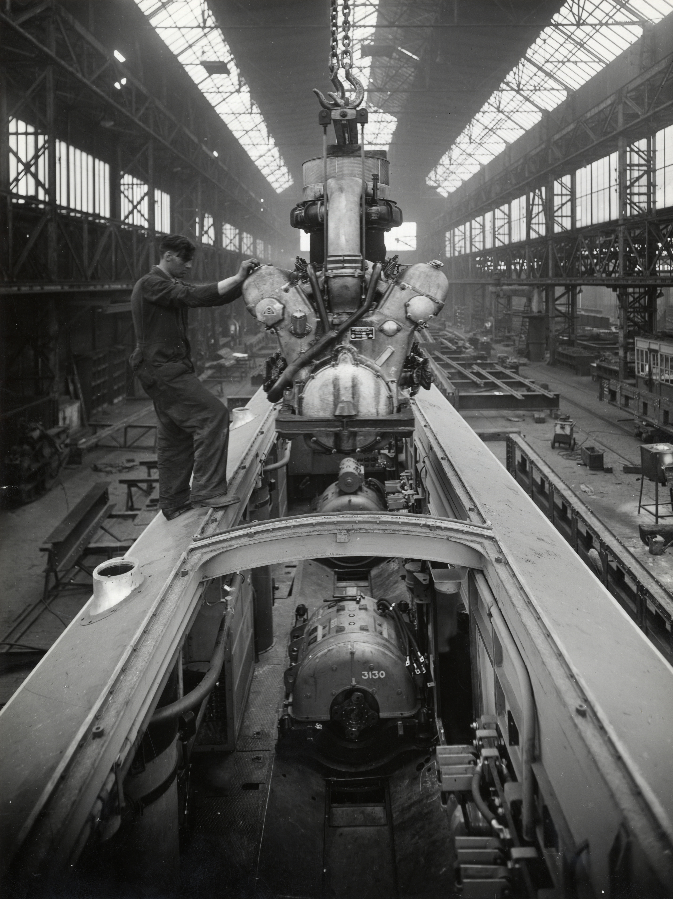 Afbeelding van een in aanbouw zijnd mD-rijtuig van een diesel-electrisch treinstel DE 5 (serie 51-68) van de N.S. bij Werkspoor te Zuilen, tijdens de plaatsing van één van de Maybach-motoren.