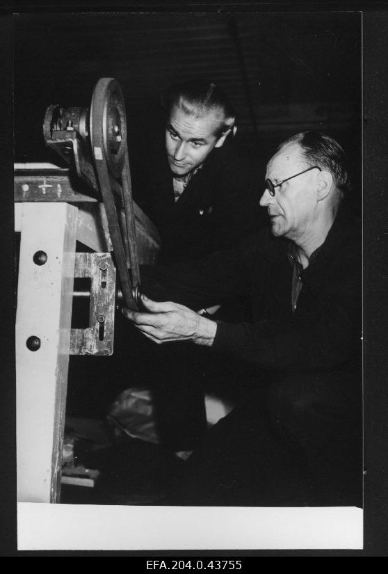 Sindi tekstiilivabriku 1. Detsember ratsionaliseerijad vahetusmeister Heino Pärkmaa (vasakul) ja Karl Kask viimistlusosakonnast villase riide mehhaniseeritud mõõtjat kokku monteerimas.