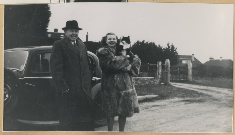 Mees ja naine seismas teele pargitud auto juures, taga paistmas elumajad