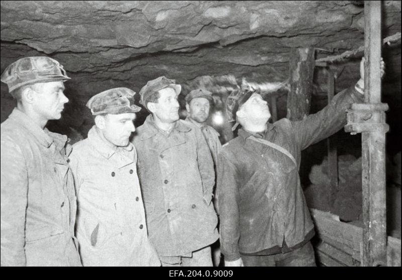 Käva kaevanduse kolmanda lõigu ülem E. Brusnitsõn selgitab eesrindlikele laavakaevureile I. Pokkile, E. Moorile, V. Perselile ja F. Astahovile laava metallilise tugevdamise eeliseid.