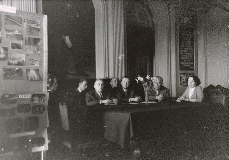 Eesti Geograafia Seltsi I konverentsi tööpresiidium:(vasakult) Salme Nõmmik (geograaf, Tartu Riiklik Ülikool), Osvald Nilson (geograaf, ENSV Pedagoogika Teadusliku Uurimise Insituut), Joosep Saat (ajaloolane, akadeemik), Endel Varep (geograaf, Tartu Riiklik Ülikool, seltsi aseesimees), Vello Tarmisto (geograaf, ENSV TA Majanduse Instituut, seltsi esimees), Hans Kruus (ajaloolane, akadeemik, ENSV TA Kodu-uurimise Komisjoni esimees), Laine Merikalju (geograaf, seltsi teadussekretär).