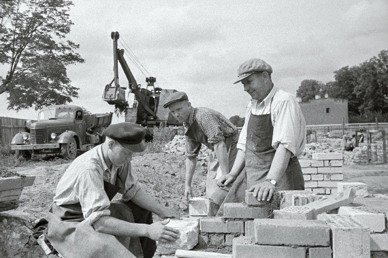 NSV Liidu Ülemnõukogu saadik vabariigi parim müüriladuja Kristjan Kärber (paremal) oma brigaadi liikmete K. Poomi (keskel) ja T. Kaskmaaga tehnikumi vundamenti ladumas Pärnu maanteel.