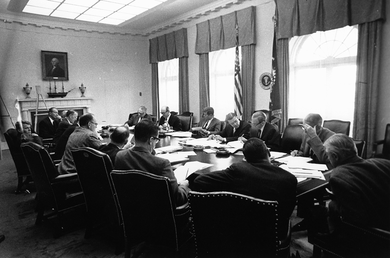 EXCOMM meeting, Cuban Missile Crisis, 29 October 1962 - ST-A26-25-62  29 October 1962  Executive Committee of the National Security Council meeting, White House, Cabinet Room.
Clockwise from President Kennedy: 

President Kennedy
Secretary of Defense Robert S. McNamara
Deputy Secretary of Defense Roswell Gilpatric
Chairman of the Joint Chiefs of Staff  Gen. Maxwell Taylor
Assistant Secretary of Defense Paul Nitze
Deputy USIA Director Donald Wilson
Special Counsel Theodore Sorensen
Special Assistant McGeorge Bundy
Secretary of the Treasury Douglas Dillon
Attorney General Robert F. Kennedy
Vice President Lyndon B. Johnson (hidden)
Ambassador Llewellyn Thompson
Arms Control and Disarmament Agency Director William C. Foster
CIA Director John McCone (hidden)
Under Secretary of State George Ball
Secretary of State Dean Rusk