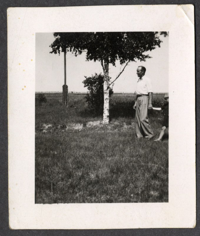 Osvald Asi väikese lapsega õues, taustal kask, elektripost ja aed