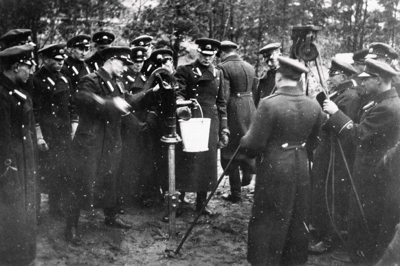 Sõjakooli ohvitserideklasside jalaväe klassi lipnikud väliõppusel enda rammitud pumbakaevust vett pumpamas.