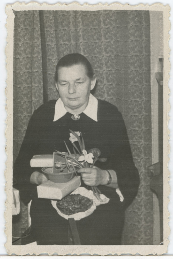 Marie Käär kingituste ja lilledega oma kodus