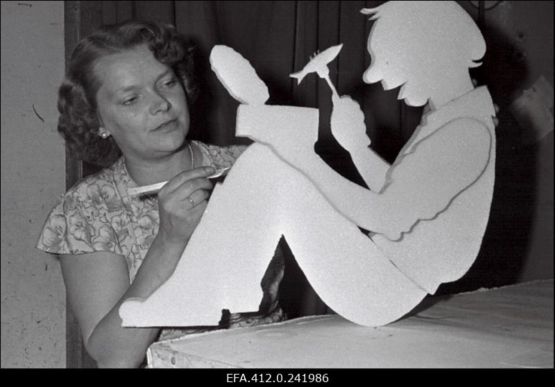 Kunstnik kaupluse vaateakna reklaami valmistamas.