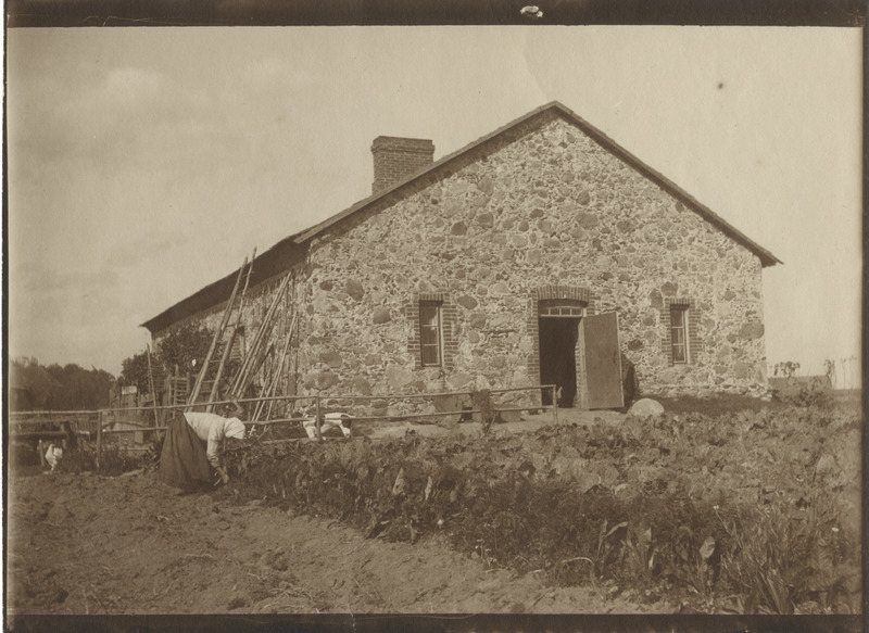 Mõisateenija peenral töötamas, esiplaanil ait