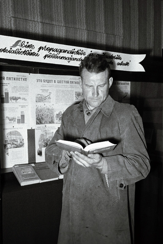 Ühise Kodu kolhoosi agronoom L. Pruus raamatukogus kirjandust valimas.