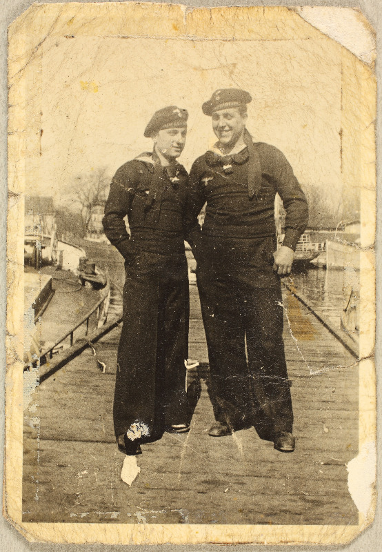 Kaks saksa mereväe vormis noormeest sillal seismas