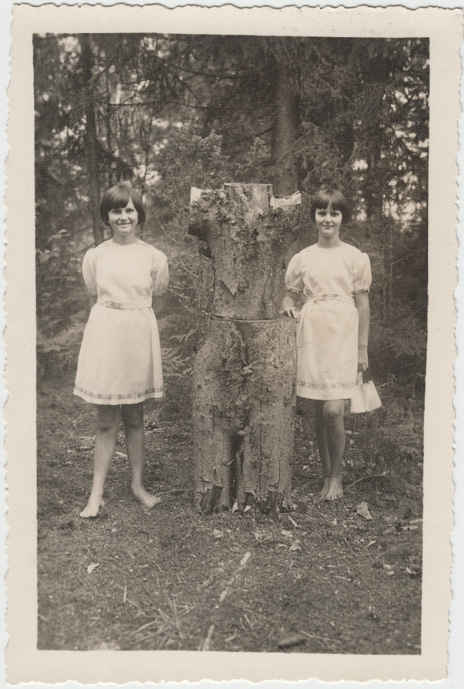 Kaks tüdrukut kändudest ehitatud kuju juures.