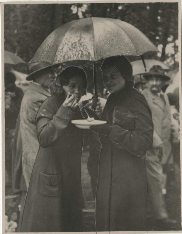 Kaitseliidu Tartu maleva ja Naiskodukaitse Tartu ringkonna vihmast tingituna luhtunud kevadpidustused Raadi pargis 21.05.1934, naised vihmavarju all suppi söömas