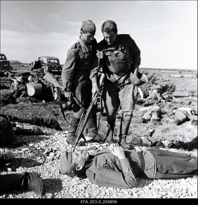 Tallinnfilmi mängufilm "Inimesed sõdurisinelis". Laipu täis lahinguväli. Kalm (Rudolf Allabert) abistab Täägerit (Heino Raudsik).