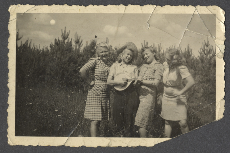 Neli naist looduses, üks neist mängib pilli