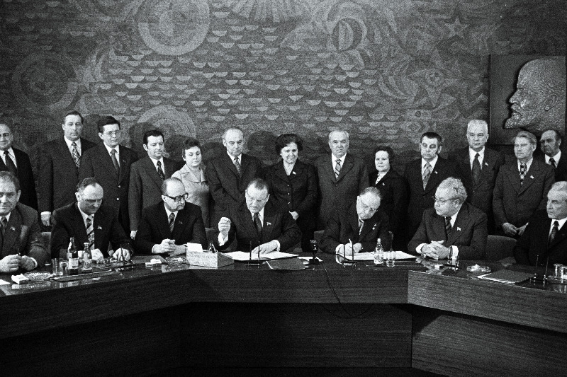 Eesti NSV ja Läti NSV töötajate 1976.a. sotsialistliku võistluse lepingule kirjutavad alla EKP Keskkomitee esimene sekretär J. Käbin (paremalt 3.) ja Läti KP Keskkomitee esimene sekretär A. Voss (paremalt 4.). Istuvad paremalt 1. ENSV Ministrite Nõukogu esimees V. Klauson, 2. ENSV Ülemnõukogu Presiidiumi esimees A. Vader. Seisavad paremalt 1. ENSV Ministrite Nõukogu esimehe asetäitja A. Green, 3. ENSV Ministrite Nõukogu esimehe asetäitja V. Käo, 4. ENSV Ministrite Nõukogu esimehe esimene asetäitja E. Tõnurist, 7. ENSV Ülemnõukogu Presiidiumi esimehe asetäitja M. Vannas.