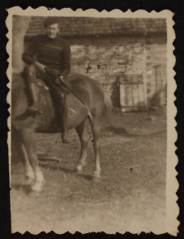 Noormees istub hobuse seljas ja hoiab käes püssi