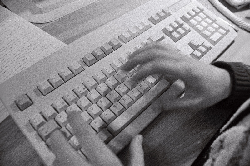 Käed arvuti klaviatuuril.