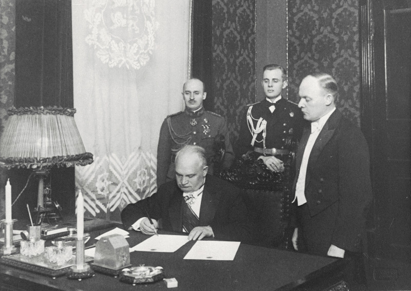 Eesti Vabariigi riigivanem K. Päts kirjutab alla uue põhiseaduse maksmahakkamise aktile. Kõrval riigisekretär K. Terras.
