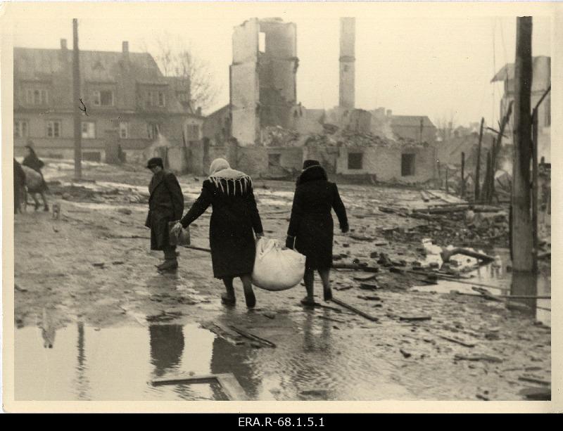 Inimesed purustatud linnatänaval oma allesjäänud vara kandmas 9. märtsi pommitamisele järgnenud päeval