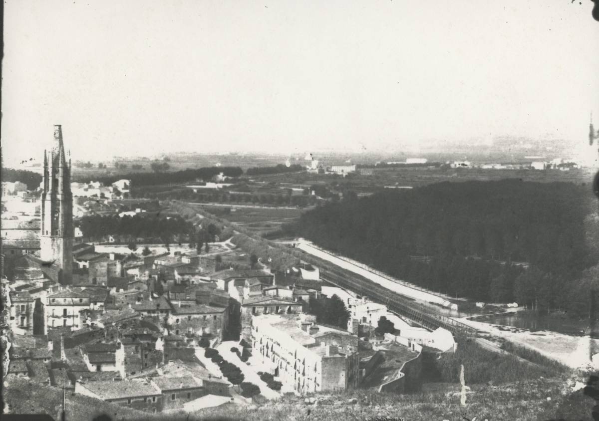 [Panoramic view from Montjuic] - Panoramic view of the city of Girona from Montjuïc. First in the centre, the Plaza de San Pedro and on the right, part of the wall of San Pedro, the railway track and the Dehesa. On the left stands the bell tower of Sant Feliu. In the background to the left, the Governor’s bulwark