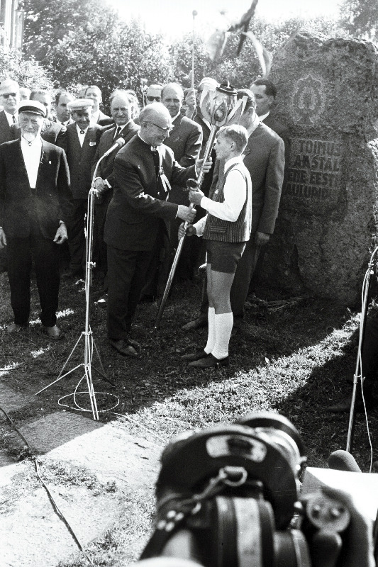 Tartu 2. Keskkooli õpilane Rein Lumiste annab Tartu juubelilaulupeo tõrviku üle Eesti NSV XVII üldlaulupeo üldjuhile Richard Ritsingule.