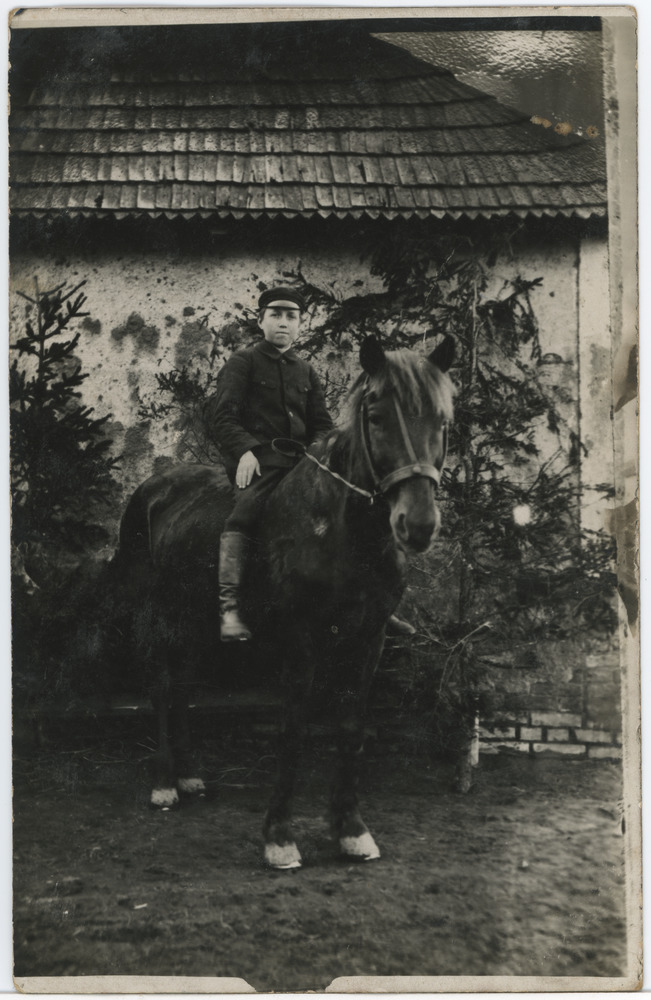 Noormees maja kõrval hobusel