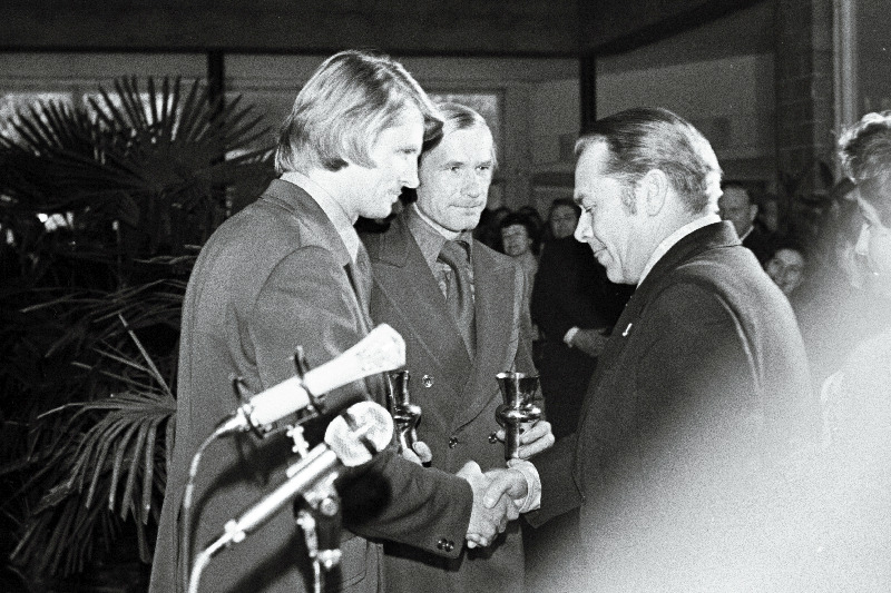 1976.a. parimate sportlaste, treenerite ja aktivistide autasustamisõhtul Lillepaviljonis annab Vabariikliku Spordikomitee aseesimees Kristjan Arusoo auhinnad parimaks tunnistatud võistkonnale - sõudjatele Gennadi Kinkole ja Tiit Helmjale.