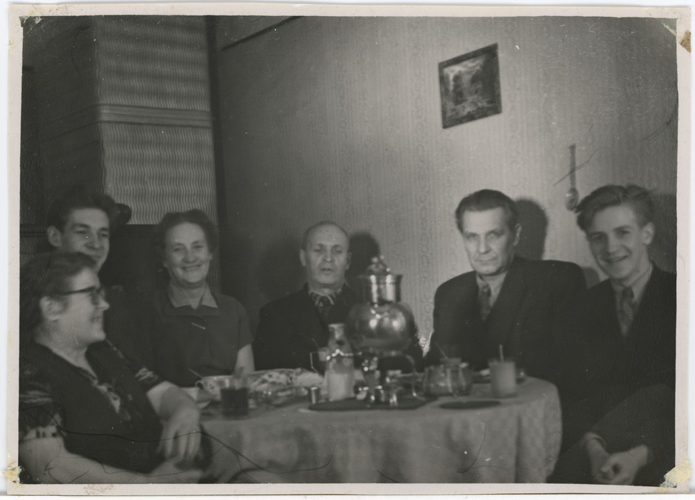 Seltskond kaetud laua ümber istumas