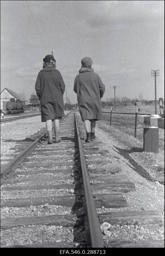 Kaks naist kaugenevad piki raudteed.
