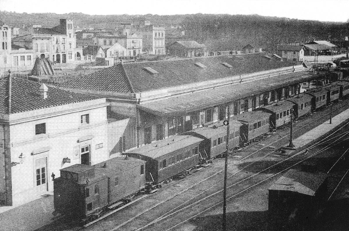 [Girona train station] - View from a high point of the train station of Girona with a convoy parked. In the background, the train station of Sant Feliu and the road to Barcelona.