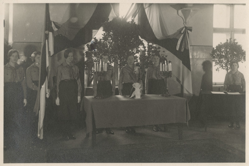 Kodutütred enne tõotuse andmist, laua taga keskel Kodutütarde peavanem Salme Pruuden