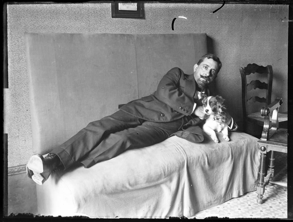 [Man with a dog] - Portrait of a stretched man, with a dog, in a room