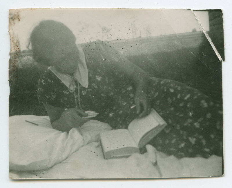 Naine voodi peal raamatut lugemas