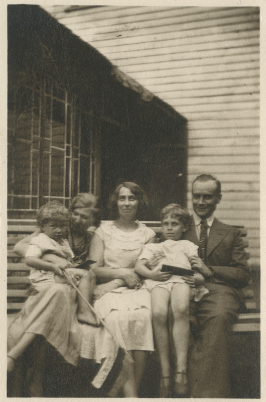 Kolm täiskasvanut koos kahe lapsega pingi peal istumas