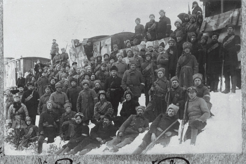 Vabadussõda. Kitsarööpalise soomusrongi nr 3 isikkoosseis Hopa (Ape) raudteejaamas. Keskel mustas poolpalitus [rongi arst Judel Kahn?], tema taga rongi komandant kapten Arved Engmann (Engmaa), A. Engmanni parema õla taga dessantroodu reamees Oskar Angelus, A. Engmanni vasaku õla taga [kuulipildujate komando ülem alamleitnant Otto Freimann?], A. Engmanni vasakul käel [dessantroodu ülem lipnik Hans Keerig?]; tagumises reas (seisab küljega käsi taskus) rongi adjutant alamleitnant Edgar Neggo, E. Neggo paremal käel kaks Taani vabatahtlike kompanii ohvitseri, A. Engmanni paremal käel (madalamal) Scoutspataljoni operatiivadjutant alamleitnant Herbert Voldemar Freiberg (Raidna), veduri uksel vedurijuht Georgi Suurevälja.