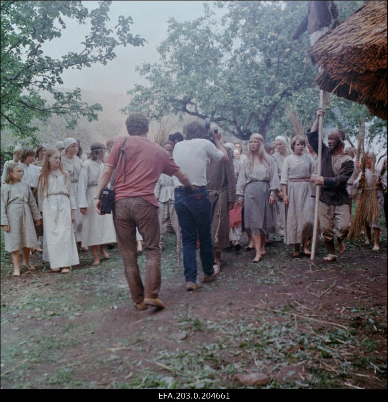 Tallinnfilmi mängufilm "Hundiseaduse aegu". Operaator-lavastaja Edvard Oja filmib massistseeni, tema taga kannab kaamera akut operaatori assistent Peeter Lõõbas.